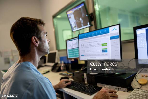 doctor in the control roomperforming a medical scan - surveillance room stock pictures, royalty-free photos & images