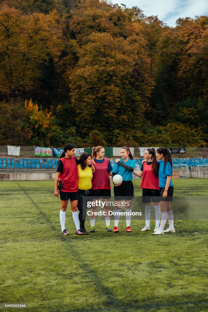 Soccer girls standing on soccer field.