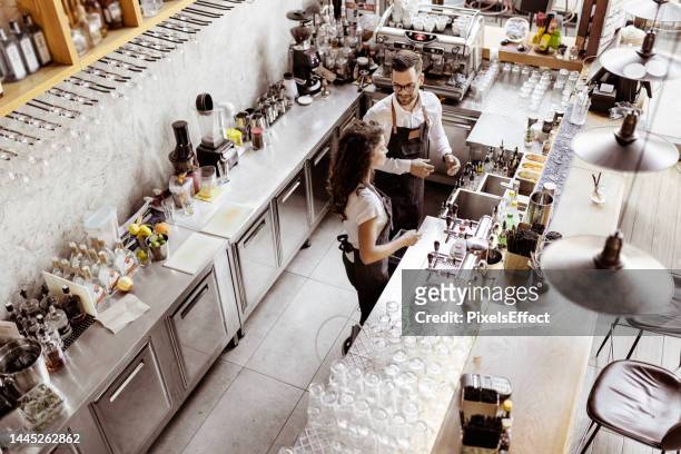 working behind bar counter - two executive man coffee shop stockfoto's en -beelden