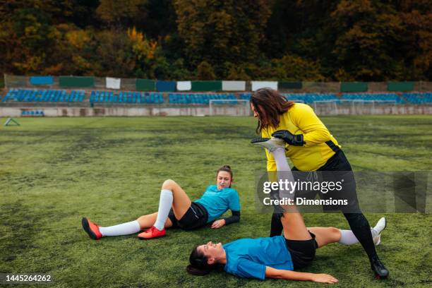 female soccer players stretching. - hamstring stock pictures, royalty-free photos & images