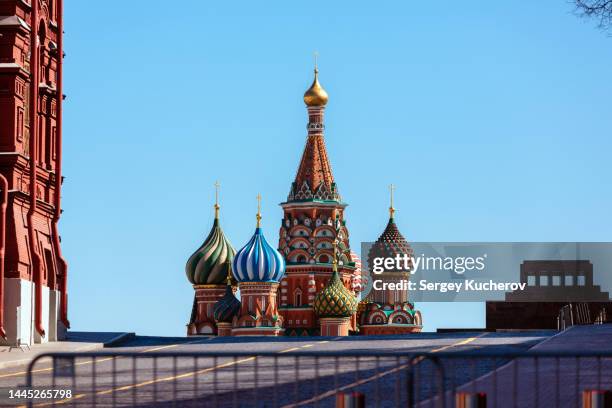 red square and saint basil's cathedral behind metal fence - cultura rusa fotografías e imágenes de stock