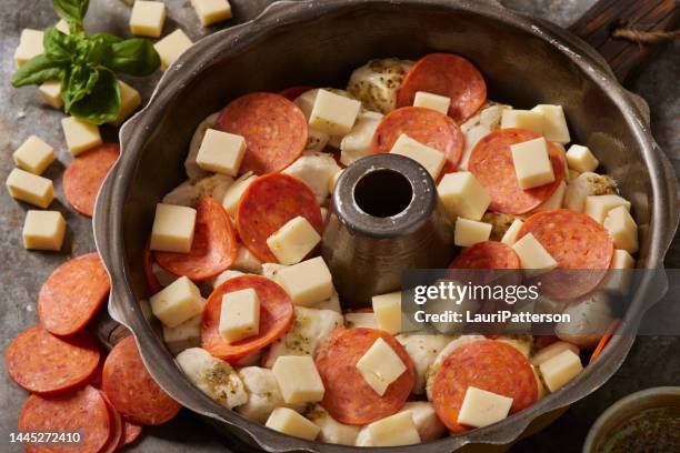 preparing pepperoni pizza pull apart monkey bread - cheese pull stockfoto's en -beelden