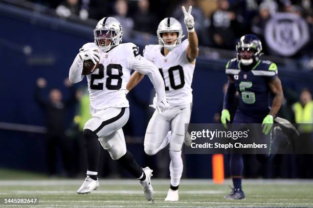 Josh Jacobs of the Las Vegas Raiders carries the ball for a touchdown in overtime to beat the Seattle Seahawks 40-34 at Lumen Field on November 27,...