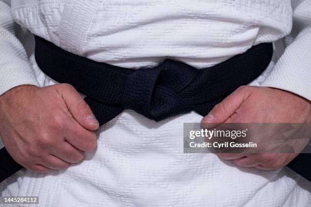 judoka holding his black belt in hands - black belt stock pictures, royalty-free photos & images