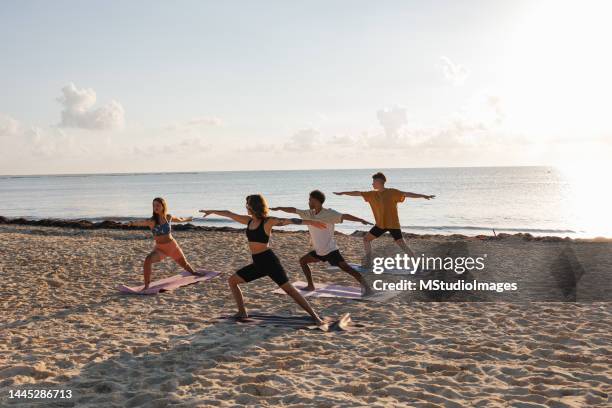 yoga class at the beach - yoga beach stock pictures, royalty-free photos & images