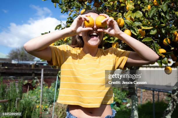 a woman in the garden with two lemons - new zealand yellow stock pictures, royalty-free photos & images