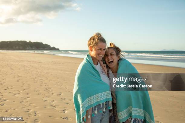 a lesbian couple walking  on the beach - nz summer bildbanksfoton och bilder