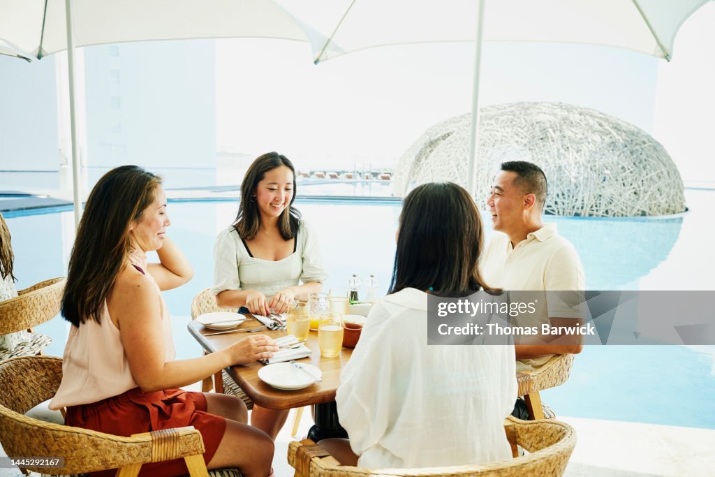 Medium shot of family seated for breakfast at outdoor restaurant