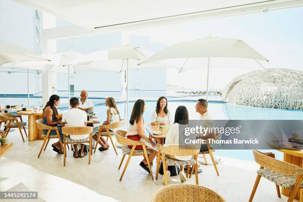 wide shot of families seated for breakfast at outdoor restaurant - mexico black and white stock-fotos und bilder