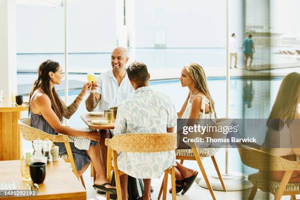 medium shot of family having for breakfast at outdoor restaurant - 4 cocktails stockfoto's en -beelden