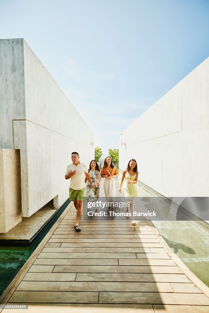 Wide shot of family walking on boardwalk at resort while on vacation