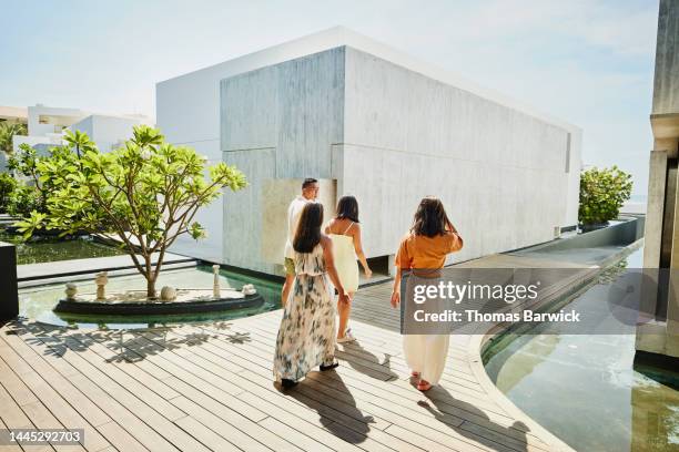 wide shot of family walking through tropical resort while on vacation - luxury family stock pictures, royalty-free photos & images