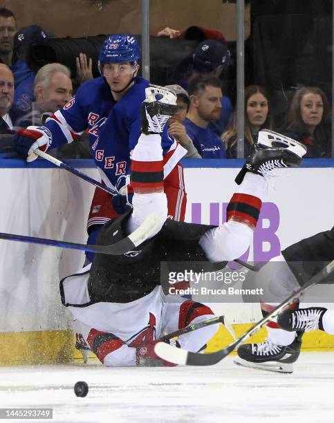 John Marino of the New Jersey Devils is tripped up during the first period against Jimmy Vesey of the New York Rangers at Madison Square Garden on...