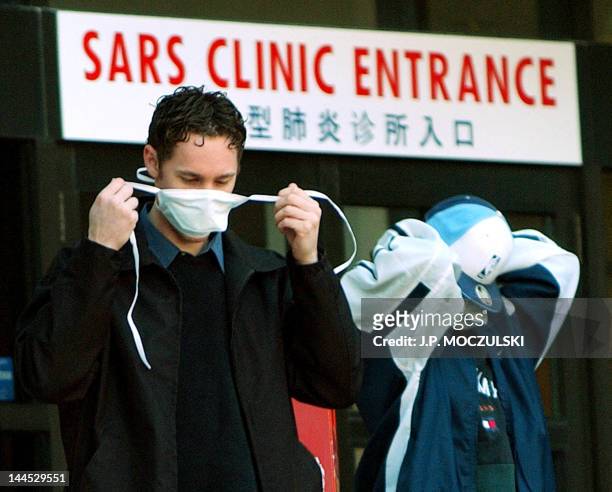 Patients put on face masks as they leave the SARS clinic setup at Sunnybrook & Women's hospital in Toronto, Canada, on 31 March, 2003. Canada has...