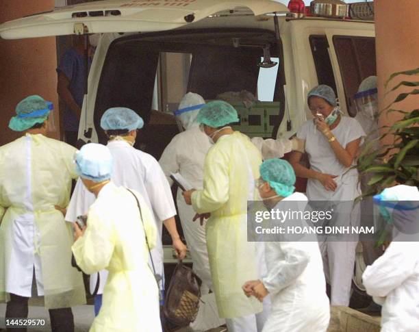 Severe Acute Respiratory Syndrome female patient is helped by doctors and nurses shortly after arriving at the Institute for Research on Tropical...