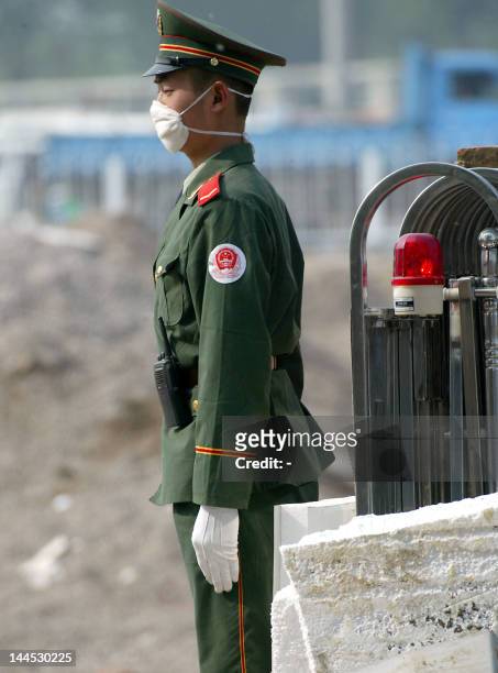 Chinese paramilitary police guards the entrance to the hospital erected in barely a week to house a rapidly increasing number of Chinese patients...