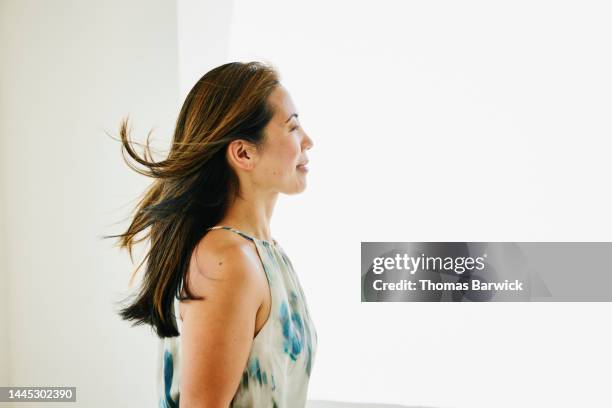 medium shot of mature woman with hair blowing in the wind - asian woman beauty shot photos et images de collection