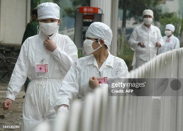Nurses walk behind a barricade at the quarantined Severe Acute Respiratory Syndrome facility of Xiaotangshan hospital, 07 May 2003, on the outskirts...
