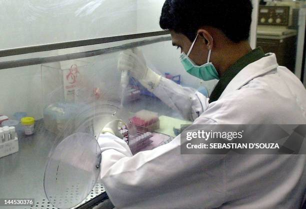 Indian laboratory researchers conduct tests at the Ranbaxy Laboratories in Bombay 07 April 2003. The tests are part of a preparatory plan to combat...