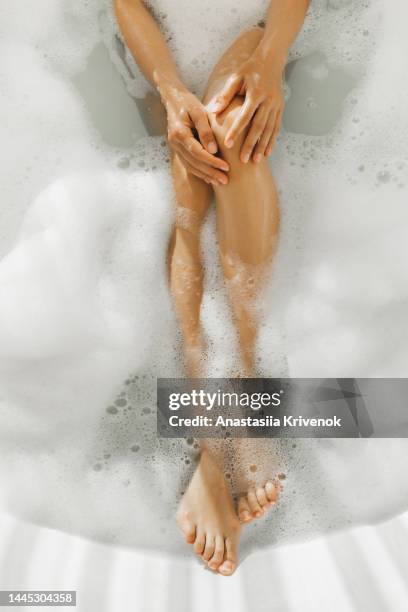 female legs in foam bubble bath. - womens pretty feet stock pictures, royalty-free photos & images