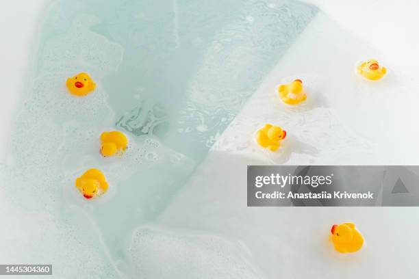 bubble bath with yellow rubber ducks. - badeend stockfoto's en -beelden