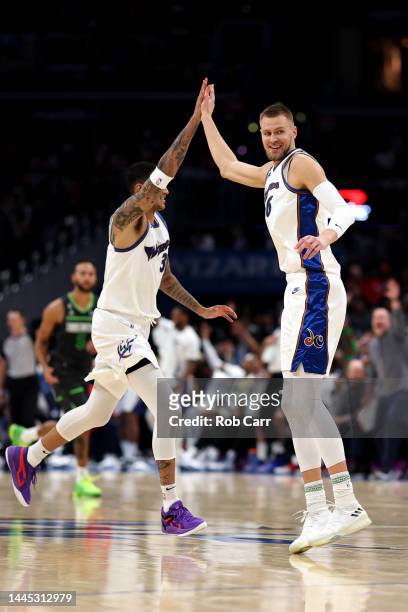 Kristaps Porzingis celebrates after hitting a three pointer in the first half with teammate Kyle Kuzma of the Washington Wizards against the...