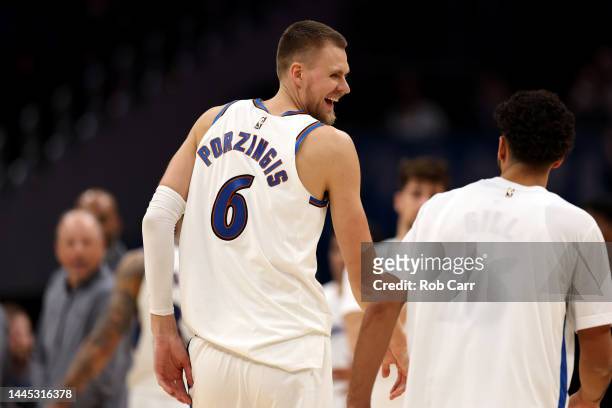 Kristaps Porzingis of the Washington Wizards talks with Anthony Gill during a second half timeout against the Minnesota Timberwolves at Capital One...
