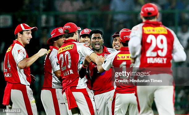 Kings XI Punjab bowler Parvinder Awana celebrates with teammates the dismissal of Delhi Daredevils batsman Ross Taylor during the IPL cricket match...