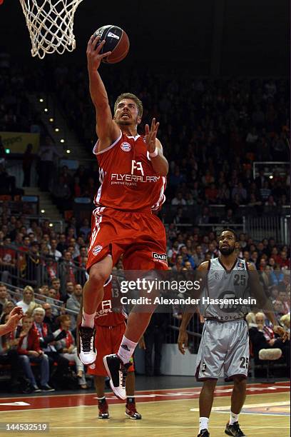 Steffen Hamann of Muenchen shoots against Brandon Thomas of Artlan Dragons during Game 4 of the BEKO BBL Quaterfinals between FC Bayern Muenchen and...