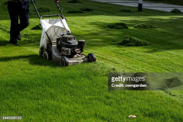 a lawn mower working in the grass - gräsklippning bildbanksfoton och bilder