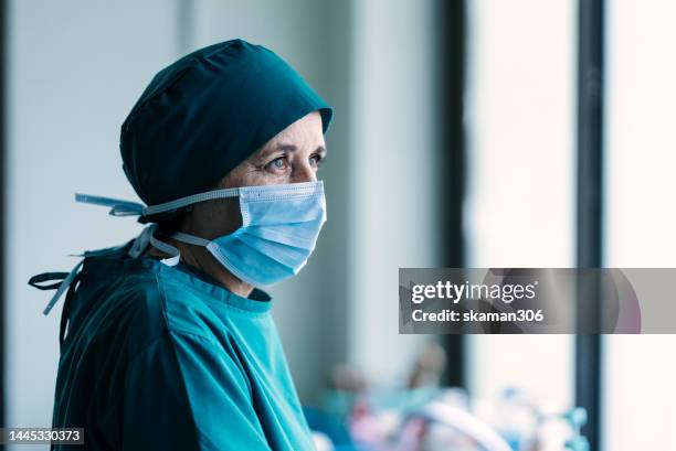 female adult surgeons exhausted and very stressed leave the operating room after a lengthy procedure and take a break. - operating room ストックフォトと画像