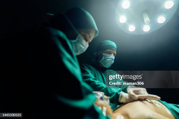 urgency accident young adult doctor performing cpr on an injured patient in the operating room. - operationstisch stock-fotos und bilder