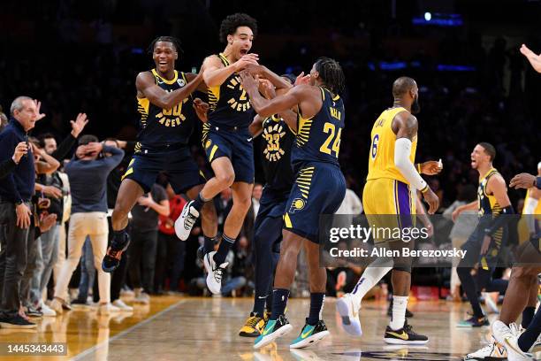 Andrew Nembhard of the Indiana Pacers celebrates with his teammates after hitting a three point buzzer-beater over LeBron James of the Los Angeles...