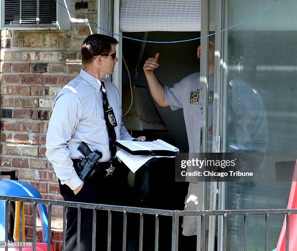 South Suburban Major Crimes Task Force investigators talk to neighbors next to the apartment building where Estrella Carrera was found stabbed to...