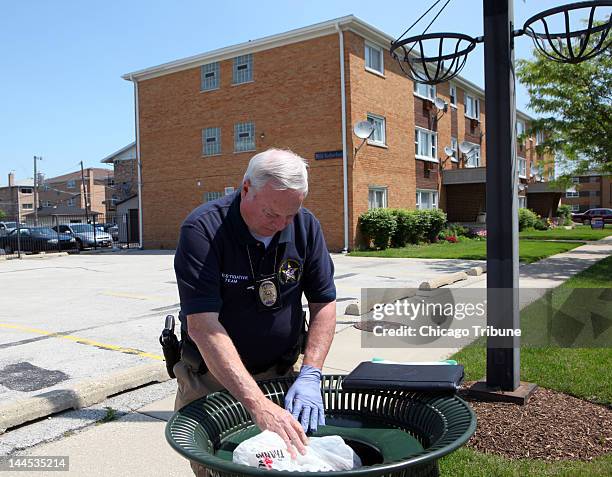 South Suburban Major Crimes Task Force investigators survey the area, including looking into trashcans, around the apartment building where Estrella...