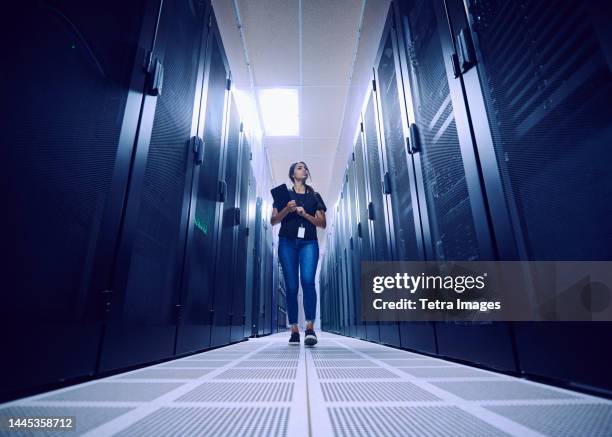 female technician walking in server room - data center front view stock pictures, royalty-free photos & images