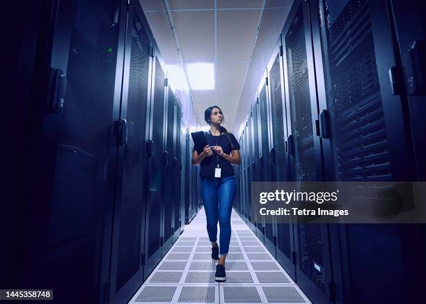 female technician walking in server room - server room stock pictures, royalty-free photos & images