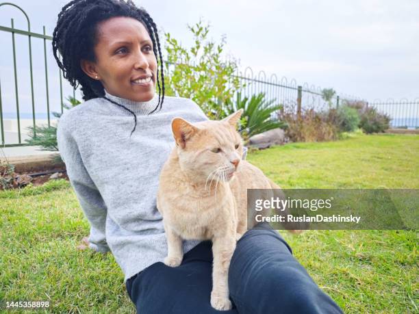 happy woman sitting with her cat outdoors. - black hairy women bildbanksfoton och bilder