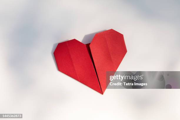 red origami heart on white background - origami fotografías e imágenes de stock