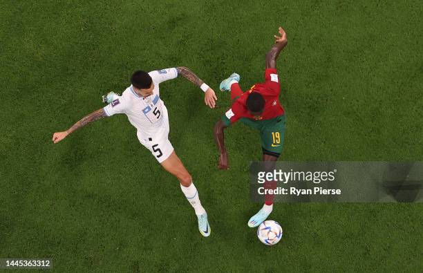 Matias Vecino of Uruguay competes for the ball against Nuno Mendes of Portugal during the FIFA World Cup Qatar 2022 Group H match between Portugal...