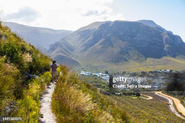 south africa, hermanus, boy (8-9) looking at small town from hiking trail in mountains - hermanus stock pictures, royalty-free photos & images