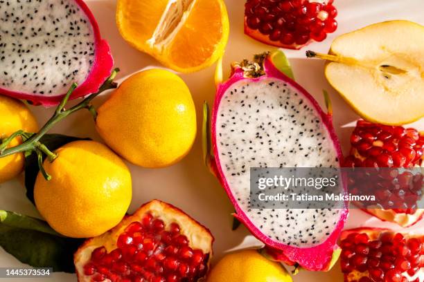 fruits close-up on a sunny day top view. pomegranate, tangerine, dragon fruit, pear. - juli bildbanksfoton och bilder