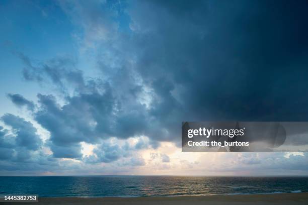 dramatic sky and dark clouds during sunset by the sea - dramatic sky stock pictures, royalty-free photos & images