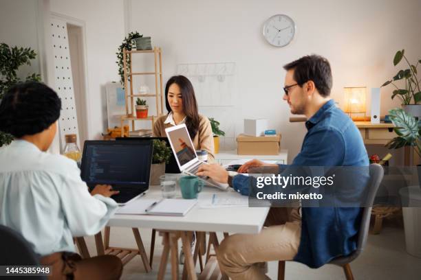 group of programmers working in a small home office - subcontratação imagens e fotografias de stock