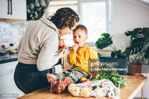 parents and children unpacking grocery in kitchen. - young man groceries kitchen stock-fotos und bilder