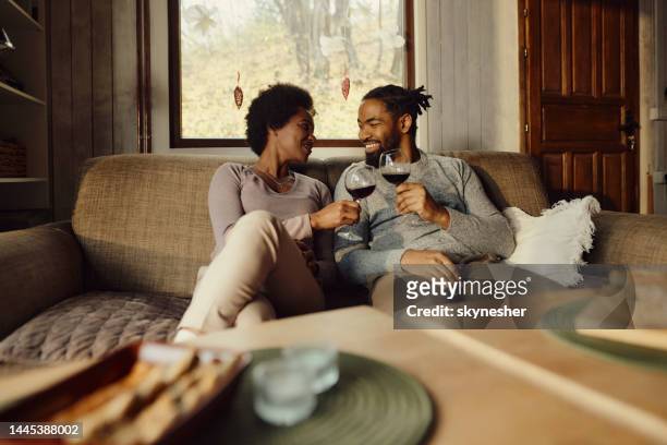 happy black couple toasting with wine at home. - wine enjoyment stock pictures, royalty-free photos & images