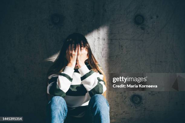 sad woman sits alone in the city. - maladie mentale photos et images de collection