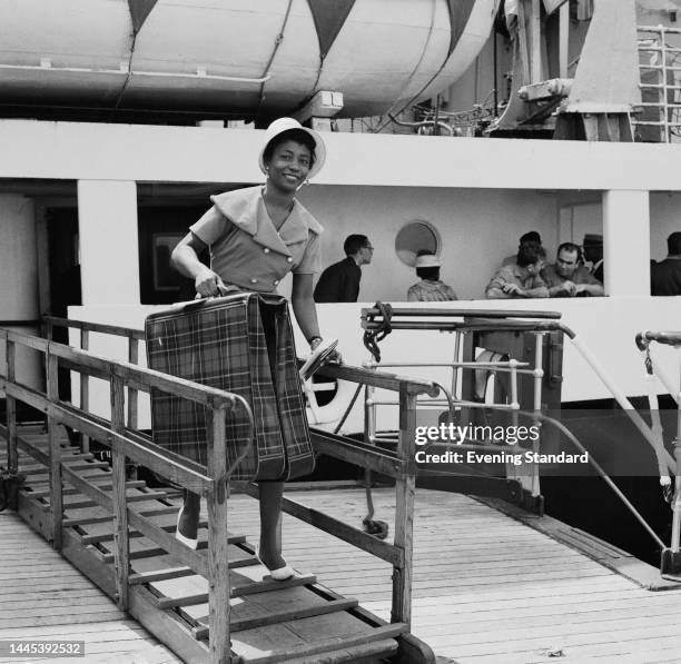 Anesta Bennet, a West Indian immigrant, arrives at Southampton docks in Hampshire carrying luggage on May 18th, 1961.