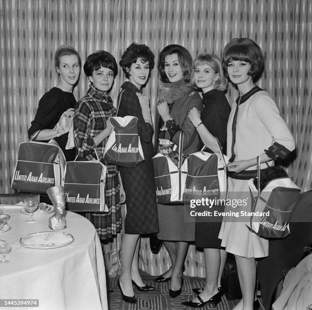 British models Norma Swift, Tania Edye, Sue Lloyd , Daphne Abrams, Primrose Austen and Paulene Stone posing with 'United Arab Airlines' bags at an...