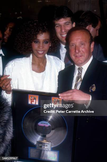 American singer Whitney Houston with President of Arista Records Clive Davis at an event to celebrate Whitney's debut album 'Whitney Houston'...